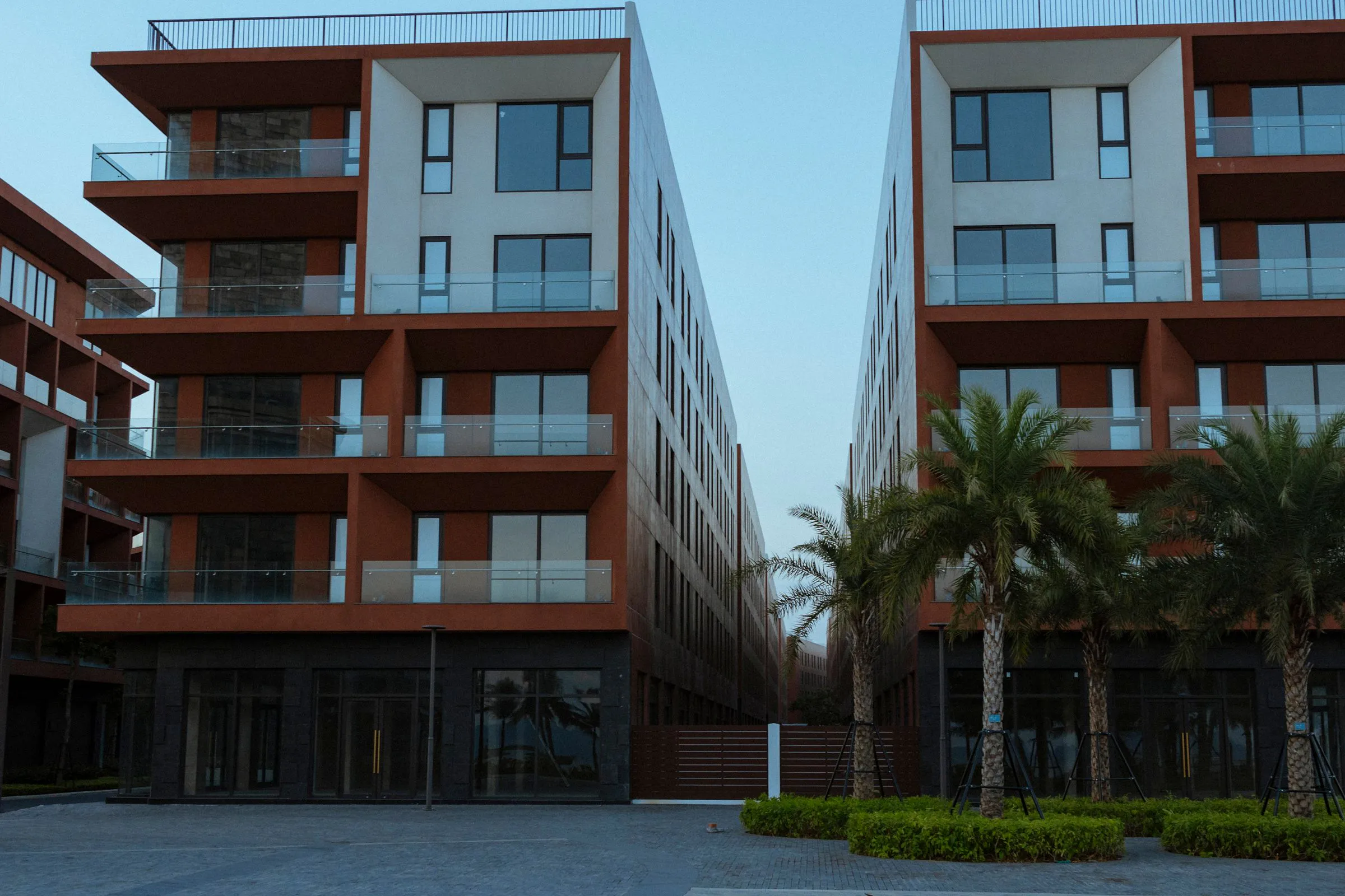 Modern apartment buildings with timber-toned balconies and palm landscaping
