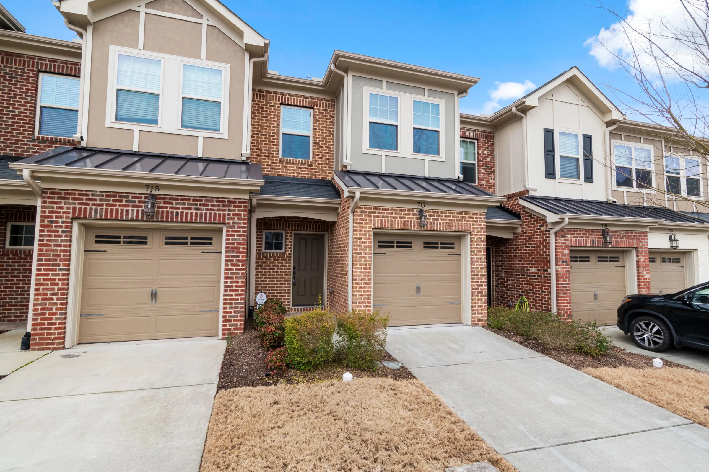 Row of residences with brick facades, generous windows and private driveways