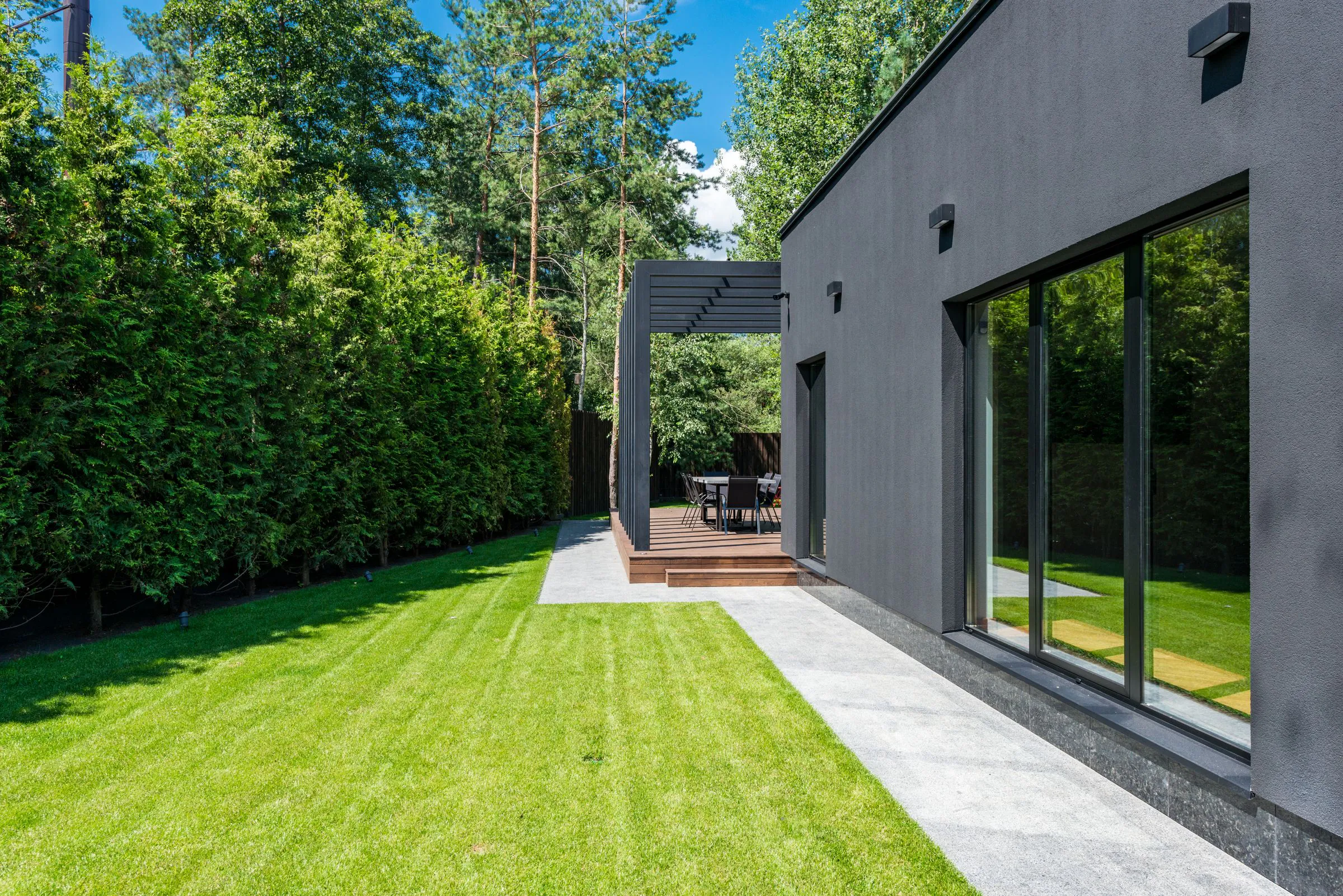 Modern garden facade beside a green lawn and mature planting